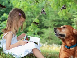 Junges Mädchen liest vor, Hund hört zu